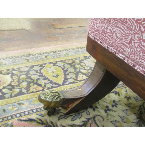 1435 - A Regency mahogany sabre leg settee with carved detail and later upholstered finish, 210cm long