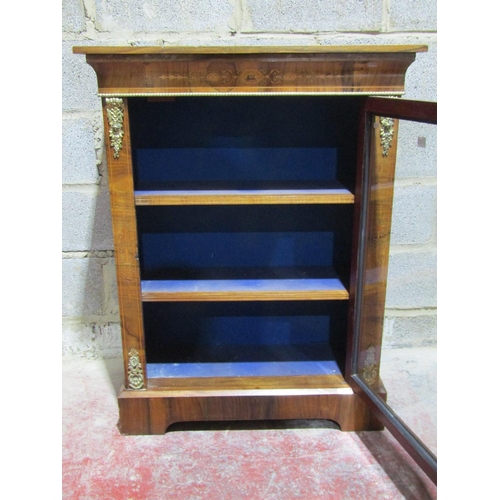 1371 - A Victorian walnut pier cabinet enclosed by a single glazed door with further brass mounts and marqu... 