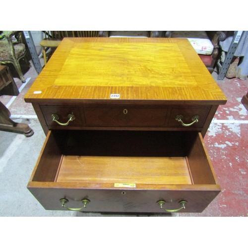 1373 - An Edwardian satin wood chest of four long graduated drawers, the top with crossbanded borders and b... 