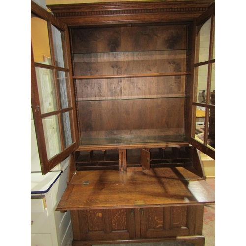 1382 - An Edwardian Oak bureau bookcase, base enclosed by 2 panelled doors, full flap enclosing a fitted in... 