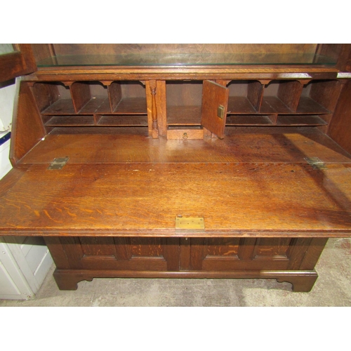 1382 - An Edwardian Oak bureau bookcase, base enclosed by 2 panelled doors, full flap enclosing a fitted in... 