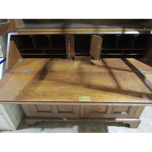 1382 - An Edwardian Oak bureau bookcase, base enclosed by 2 panelled doors, full flap enclosing a fitted in... 