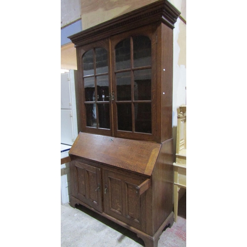 1382 - An Edwardian Oak bureau bookcase, base enclosed by 2 panelled doors, full flap enclosing a fitted in... 