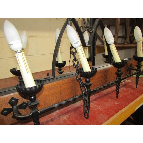 1410 - A gothic style ceiling light in oak and wrought iron bearing eight sconces, 110 cm length x 55 cm hi... 