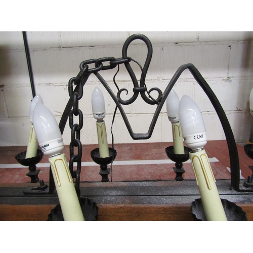 1410 - A gothic style ceiling light in oak and wrought iron bearing eight sconces, 110 cm length x 55 cm hi... 