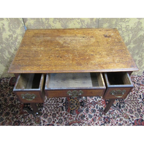 1502 - A George III country oak lowboy, the drawers cross banded in walnut with central apron, raised on sq... 