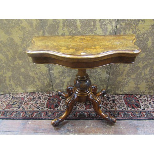 1529 - A Mid-Victorian period figured walnut serpentine card table raised on a turned and carved pillar and... 