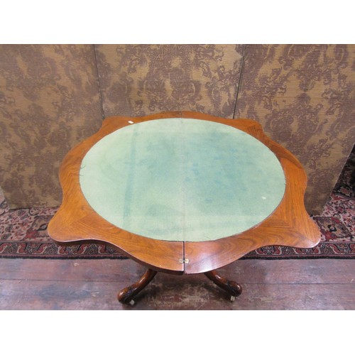 1529 - A Mid-Victorian period figured walnut serpentine card table raised on a turned and carved pillar and... 