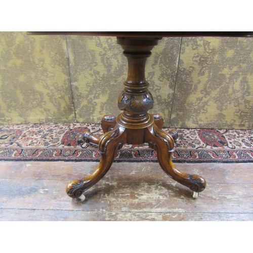 1529 - A Mid-Victorian period figured walnut serpentine card table raised on a turned and carved pillar and... 