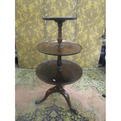 1530 - A George III mahogany three tier dumb waiter with turned column and tripod base, 120cm high