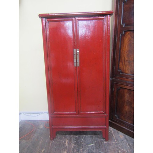 A decorative Chinese crimson lacquered hanging cupboard of tapering form, 180 cm high, 90cm x 43cm