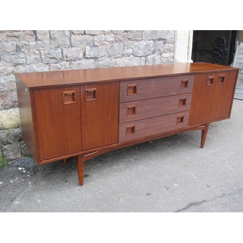 1150 - A Mid 20th century long and low teak sideboard by Elliotts of Newbury, partially enclosed by side cu... 