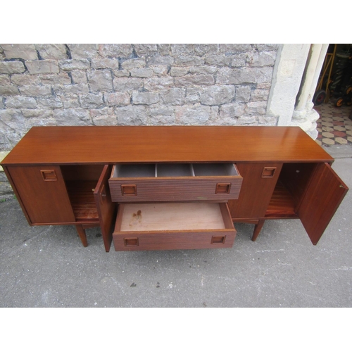 1150 - A Mid 20th century long and low teak sideboard by Elliotts of Newbury, partially enclosed by side cu... 