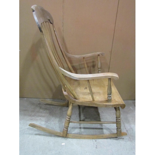 1160 - An antique stripped pine and beechwood Boston stick back rocking chair with shaped and scrolled seat