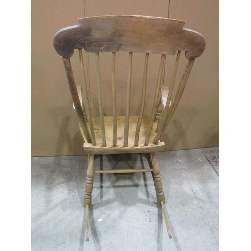 1160 - An antique stripped pine and beechwood Boston stick back rocking chair with shaped and scrolled seat