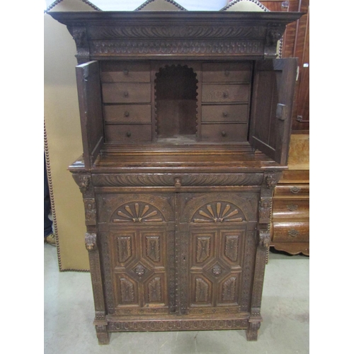 1177 - A Victorian gothic oak two sectional side cupboard in the old English style, the front elevation enc... 