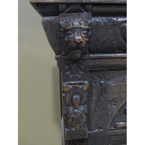 1177 - A Victorian gothic oak two sectional side cupboard in the old English style, the front elevation enc... 