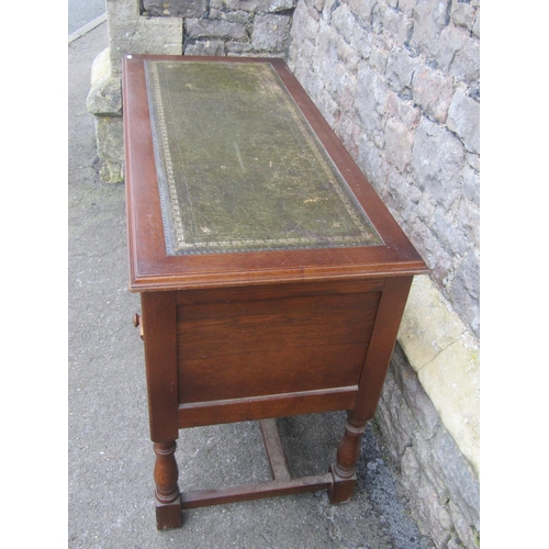 1191 - A reproduction oak writing table/desk with inset leather panel top over an arrangement of five friez... 