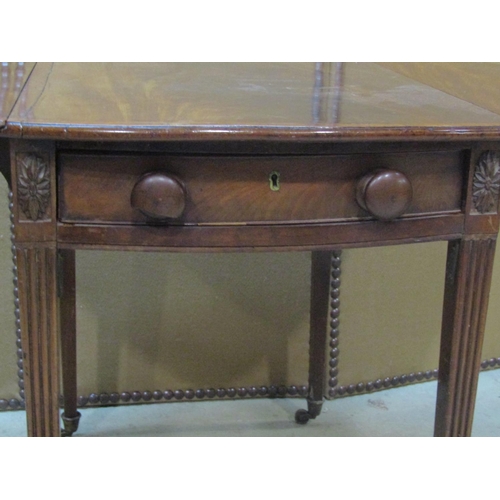 1199 - A Georgian mahogany oval drop leaf Pembroke table with crossbanded detail and usual arrangement of o... 