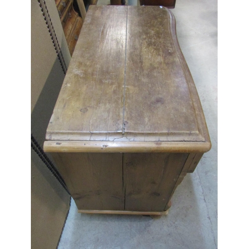 1203 - A small Victorian stripped pine  kitchen dresser with serpentine front enclosed by recessed moulded ... 