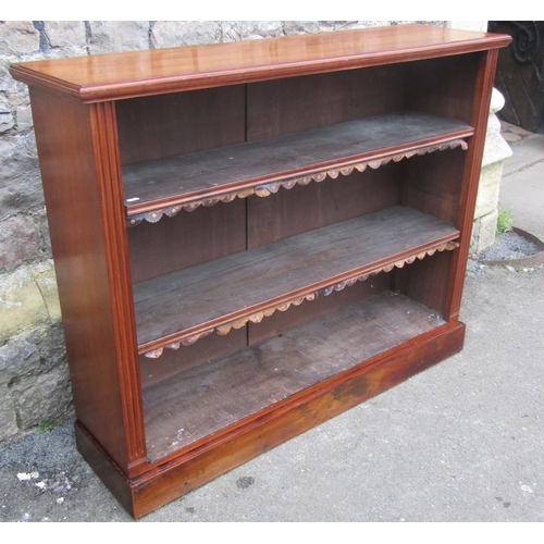 1300 - A late Victorian walnut floorstanding open bookcase with two adjustable shelves and set on a plinth,... 