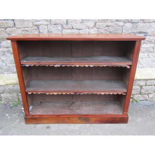 1300 - A late Victorian walnut floorstanding open bookcase with two adjustable shelves and set on a plinth,... 