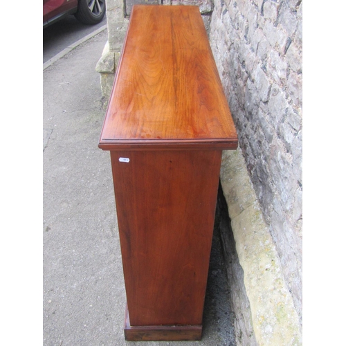 1300 - A late Victorian walnut floorstanding open bookcase with two adjustable shelves and set on a plinth,... 