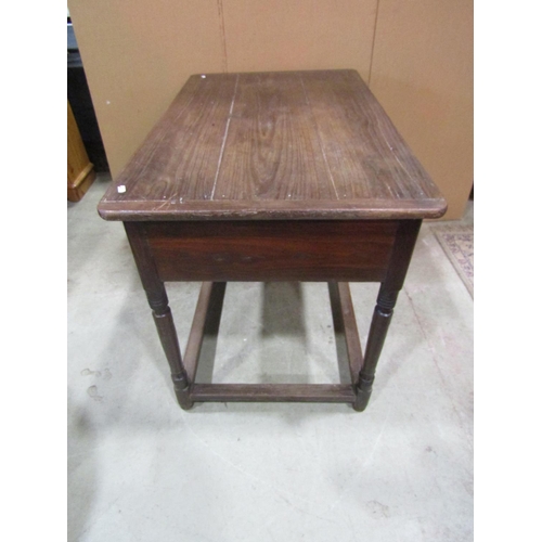 1153 - An antique oak stained pine side table, the plank top with cleated ends over a frieze drawer and tur... 