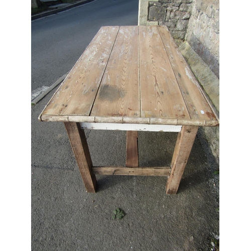 1163 - A rustic pine kitchen table, the rectangular boarded top with split bamboo moulded surround raised o... 