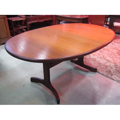 1240 - A G plan teak D end pull out extending dining table with single additional bi-fold leaf raised on sh... 