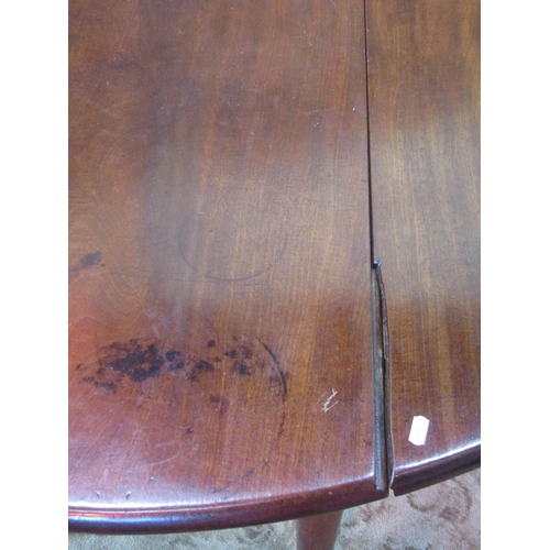 1250 - A Georgian mahogany oval dropleaf dining table raised on simple turned tapered legs with brass caps ... 