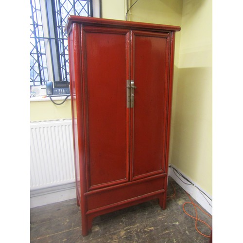 1538 - A decorative Chinese crimson lacquered hanging cupboard of tapering form, 180 cm high, 90cm x 43cm