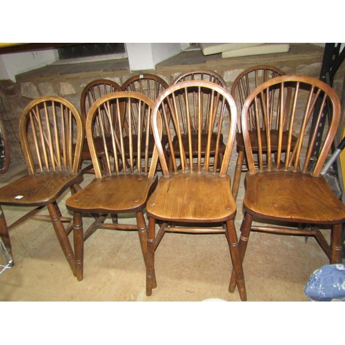 1111 - A set of eight Windsor elm and beechwood hoop and stick back dining chairs with saddle shaped seats ... 