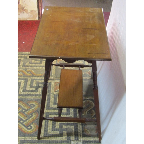 1304 - An Edwardian Arts & Crafts style walnut two tier  occasional table of rectangular form raised on tur... 