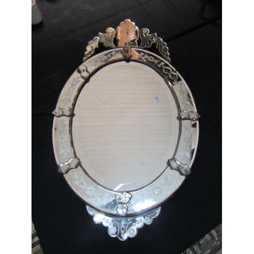 1321 - A  Venetian wall mirror of oval form with applied segmented floral plates (one piece loose) 97 cm x ... 