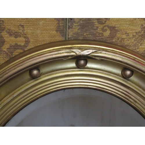 1330 - An Oval gilt framed wall mirror with bevelled edge plate, ball surround, with reeded and cross hatch... 