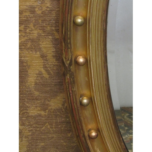 1330 - An Oval gilt framed wall mirror with bevelled edge plate, ball surround, with reeded and cross hatch... 