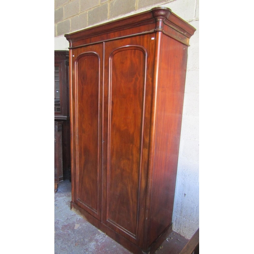 1351 - A substantial Victorian mahogany wardrobe with turret corners enclosed by a pair of arched and panel... 