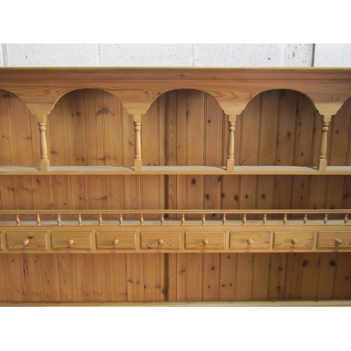 1354 - A large stripped pine kitchen dresser, the base enclosed by a T shaped arrangement of eight drawers,... 