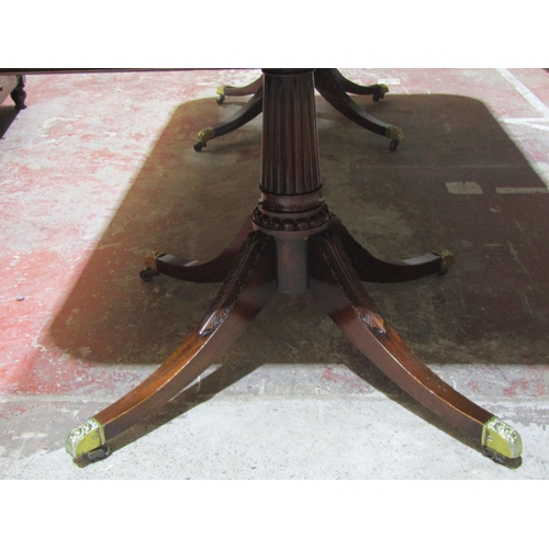 1375 - A Regency mahogany twin pedestal dining table with fluted columns and swept acanthus supports with t... 