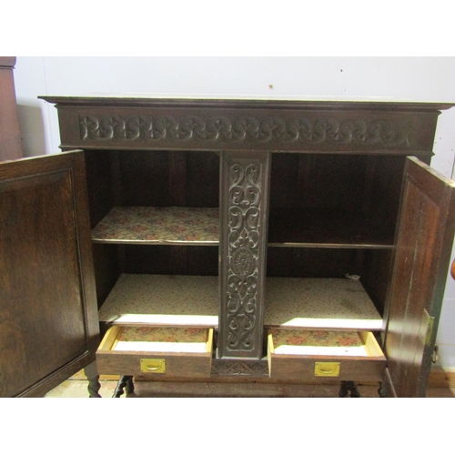 1387 - Edwardian oak cabinet enclosed by two carved and panelled doors with open framework on barley twist ... 