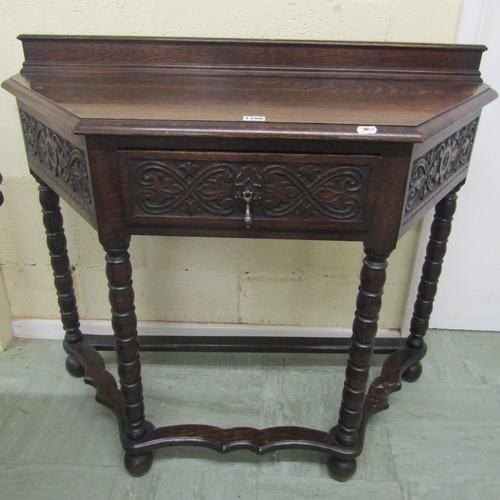 1396 - Edwardian oak side table in a Jacobean style, with canted corners enclosing a frieze drawer on bobbi... 