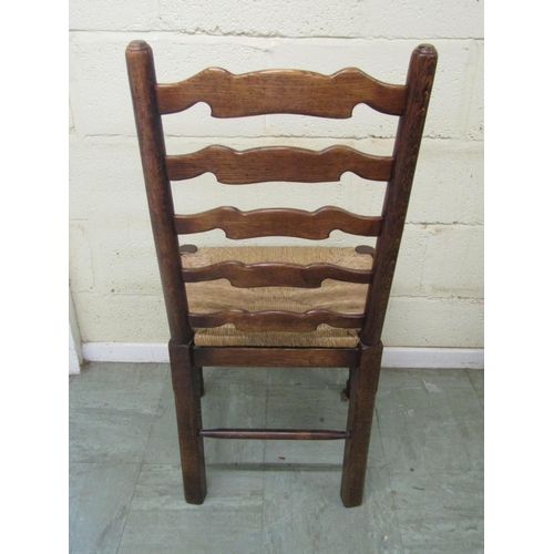 1399 - A set of six oak ladderback chairs (4+2) with rush seats and pad feet on turned supports