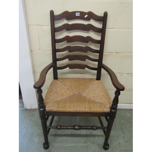 1399 - A set of six oak ladderback chairs (4+2) with rush seats and pad feet on turned supports