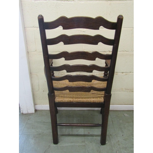 1399 - A set of six oak ladderback chairs (4+2) with rush seats and pad feet on turned supports