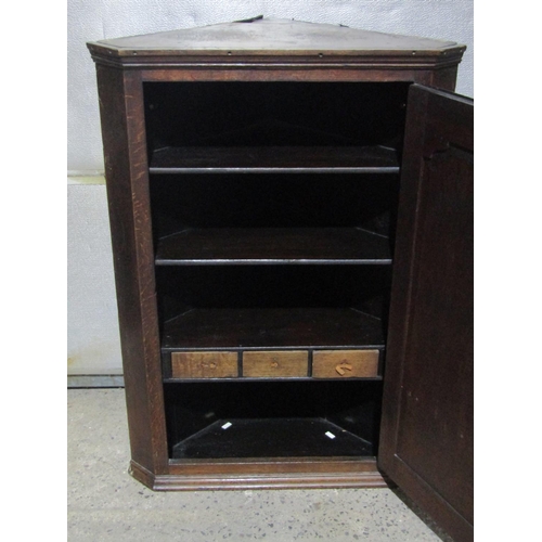 1367 - A Georgian oak hanging corner cupboard enclosed by a arched panel doors enclosing an arrangement spi... 