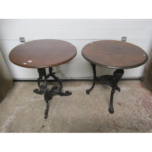 1412 - Two cast iron pub tables of varying design with circular oak tops