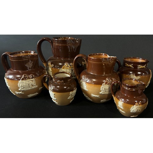 123 - Collection of Doulton stoneware jugs with applied detail in varying sizes (12)