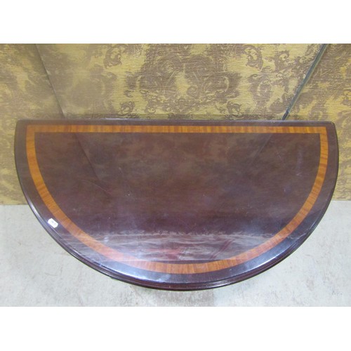 1204 - A cross-banded demi-lune mahogany hall table, 76cm high, 91 cm wide