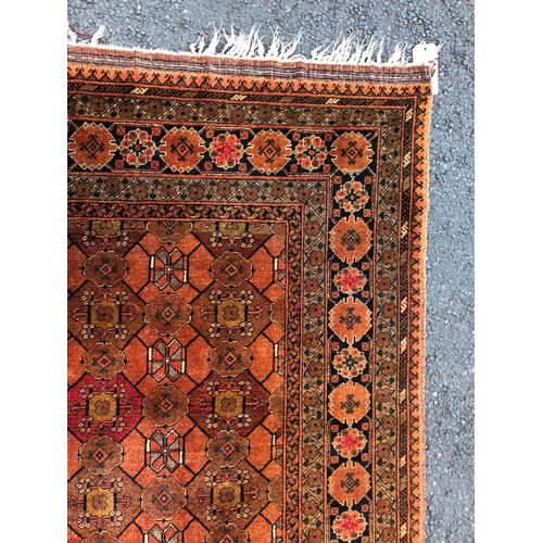 1546 - A Persian/Afghan rug with multi-medallion centre on ochre ground within alternating running borders,... 